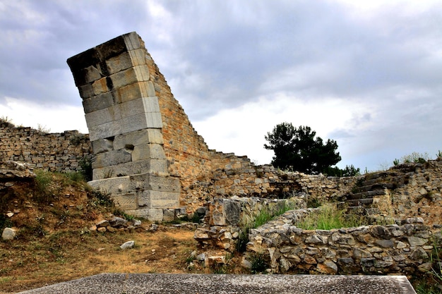 Vista a basso angolo del sito archeologico contro un cielo nuvoloso