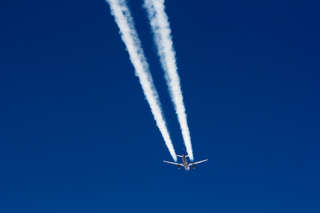 Vista a basso angolo dell'aereo e della traccia di vapore nel cielo