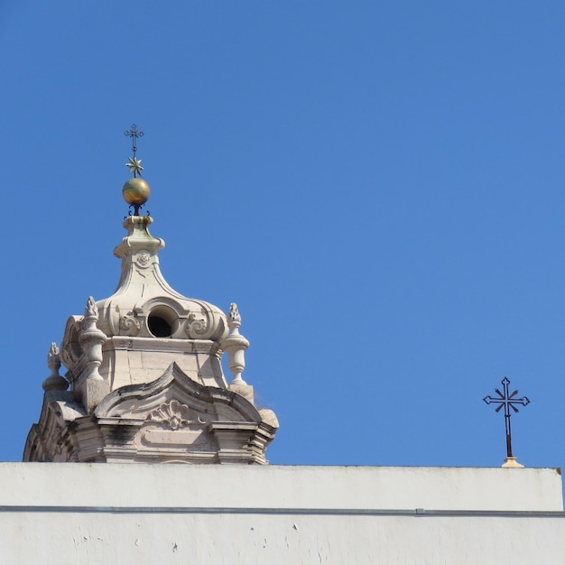 Vista a basso angolo della croce contro un cielo blu limpido