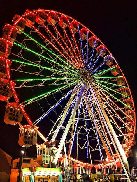 Vista a basso angolo della ruota panoramica illuminata contro il cielo di notte