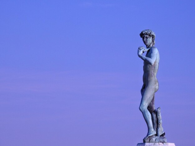 Vista a basso angolo della statua contro il cielo blu durante il tramonto