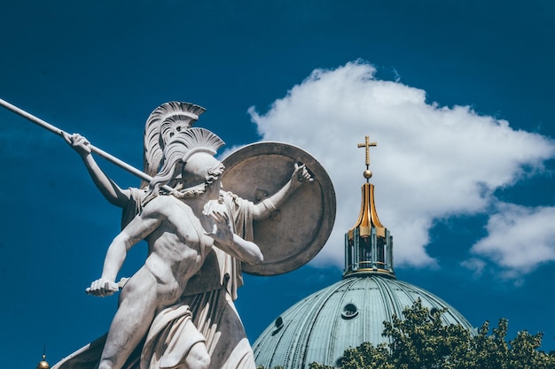 Vista a basso angolo della statua e della chiesa contro il cielo