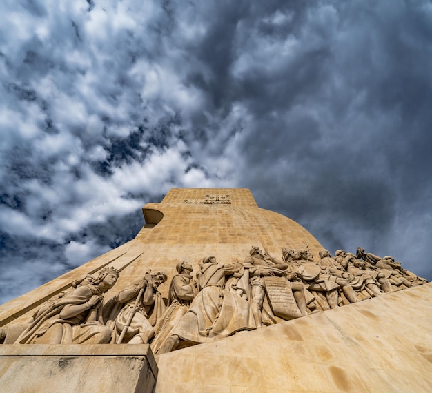 Vista a basso angolo delle sculture in pietra calcarea dei navigatori pionieri al Monumento alle Scoperte