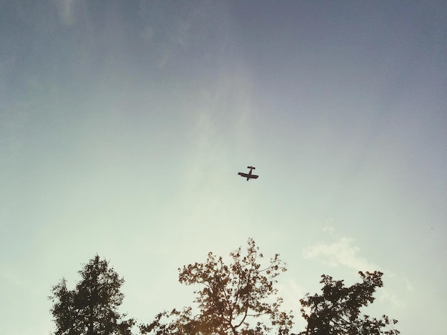 Vista a basso angolo di un aereo a silhouette che vola contro il cielo