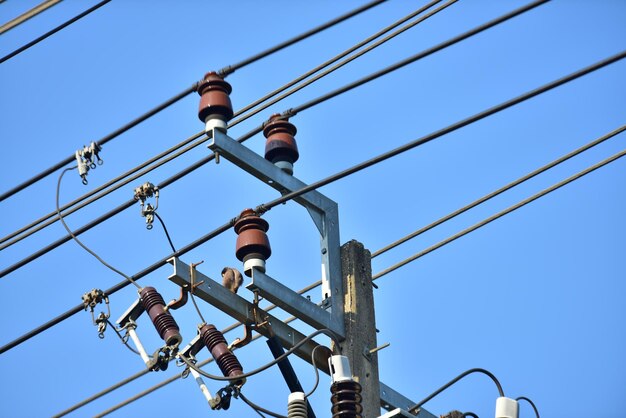 Vista a basso angolo di un palo telefonico contro un cielo blu limpido