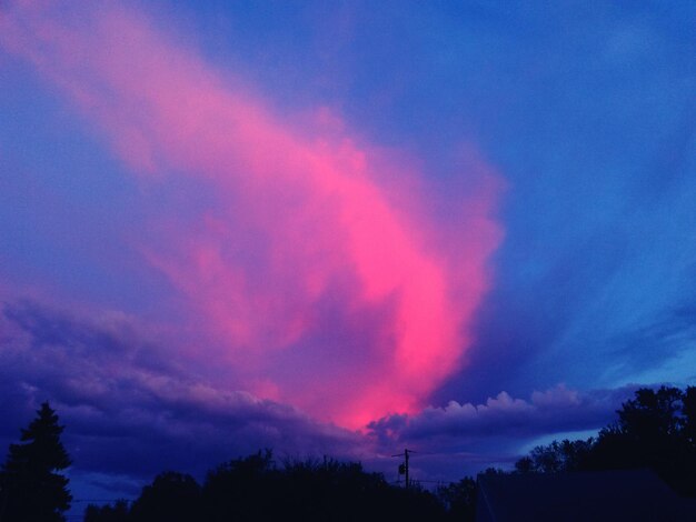 Vista a basso angolo di una nuvola rosa nel cielo blu al crepuscolo