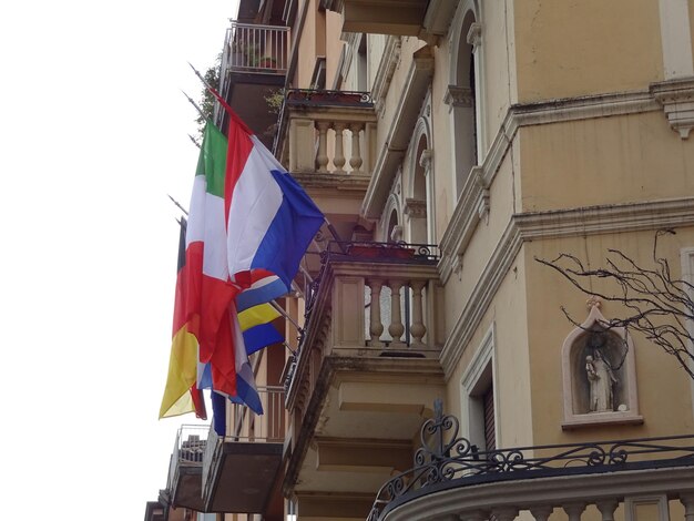 Vista a basso angolo di varie bandiere nazionali sul balcone