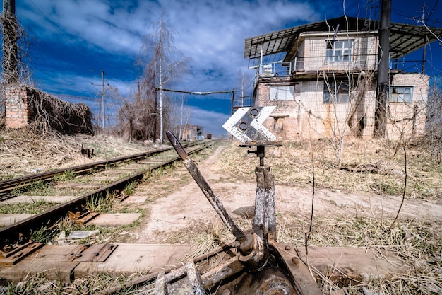 Vista a tutta lunghezza delle rotaie vuote senza persone. Cielo blu. Estate. Stazione ferroviaria abbandonata e concetto di trasporto