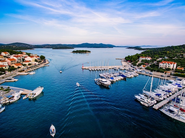 Vista a volo d'uccello del drone aereo del piccolo porto turistico con barche e yacht ormeggiati in Croazia