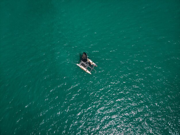 Vista a volo d'uccello del piccolo kayak a vela; vele nere al vento. Concetto di regata.