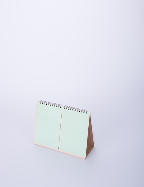 Vista ad alta angolazione del calendario verde vuoto su sfondo bianco