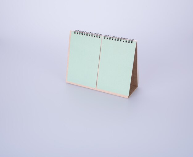 Vista ad alta angolazione del calendario verde vuoto su sfondo bianco