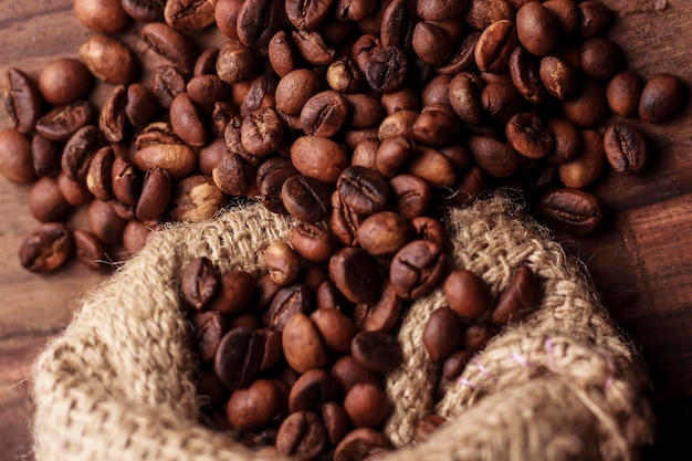 Vista ad alta angolazione del chicco di caffè arrostito versato dalla borsa di iuta