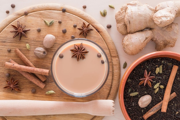 Vista ad alta angolazione del tè con gli ingredienti in vetro su un tavolo da taglio sopra il tavolo