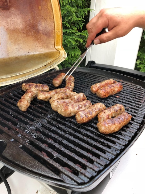 Vista ad alta angolazione della carne cevapcici sulla griglia da barbecue