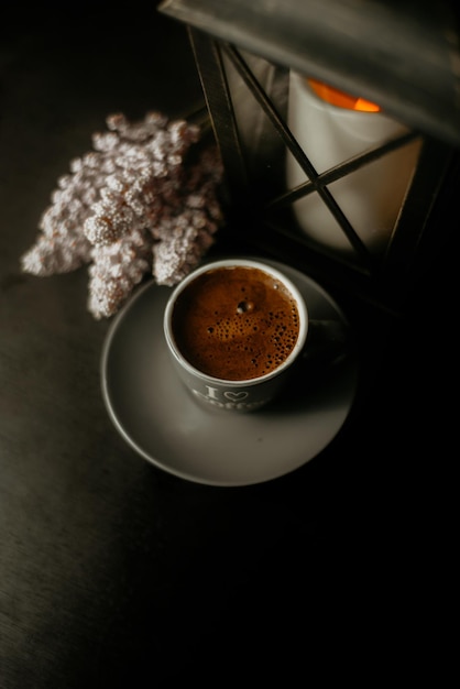 Vista ad alta angolazione della tazza di caffè con la lanterna sul tavolo