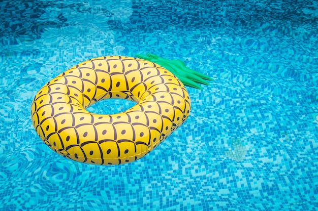 Vista ad alta angolazione della zattera gonfiabile di ananas giallo nella piscina