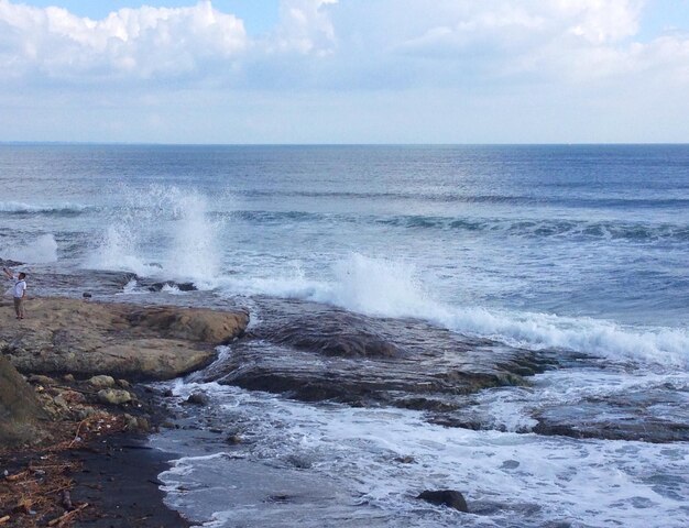 Vista ad alta angolazione delle onde marine che schizzano sulle formazioni rocciose