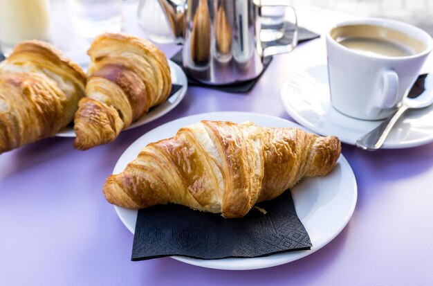 Vista ad alta angolazione di croissant freschi e caffè serviti sul tavolo al caffè