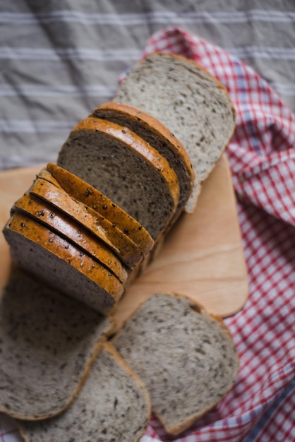 Vista ad alta angolazione di fette di pane integrale sul tavolo da taglio