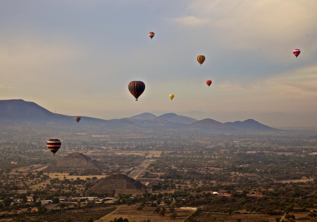 Vista ad alta angolazione di palloncini ad aria calda che volano sopra il paesaggio