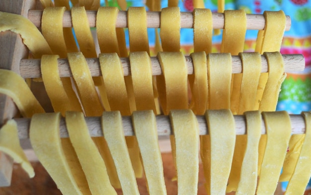 Vista ad alta angolazione di spaghetti crudi su barre di legno