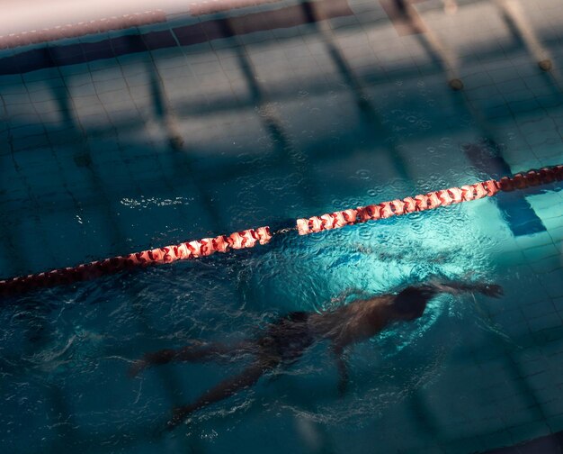 Vista ad alta angolazione di un uomo che nuota in piscina