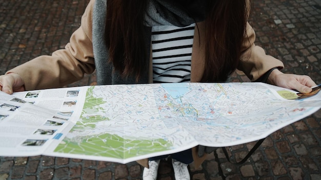 Vista ad alta angolazione di una donna che legge la mappa per strada