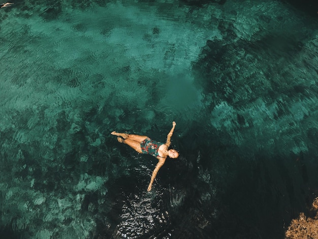 Vista ad alta angolazione di una donna che nuota in mare