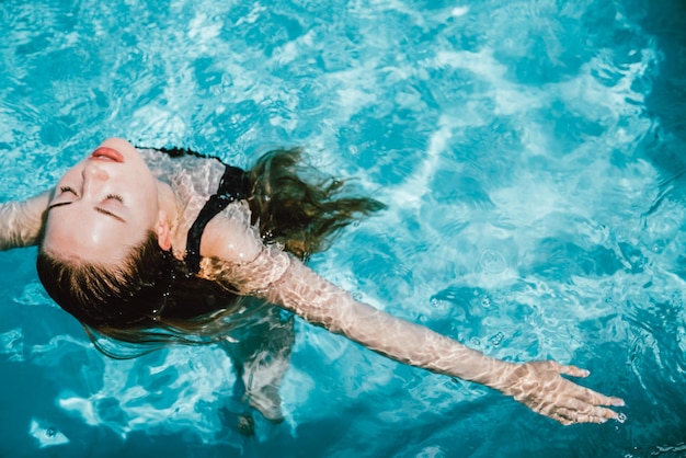 Vista ad alta angolazione di una donna che nuota in piscina