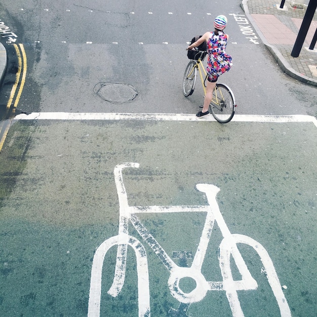 Vista ad alta angolazione di una donna in bicicletta per strada