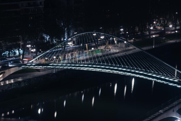 Vista ad alta prospettiva a lunga esposizione del ponte Zubizuri di notte a Bilbao Spagna effetto tilt shift