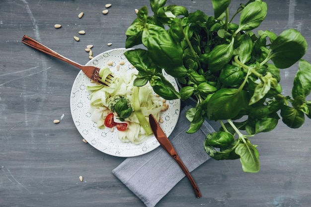 Vista ad alto angolo del cibo nel piatto con il basilico sulla tavola