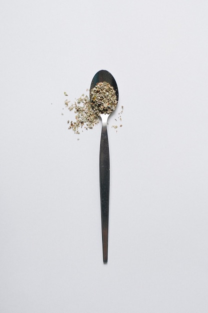 Vista ad alto angolo dell'ingrediente nel cucchiaio su sfondo bianco