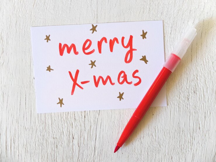 Foto vista ad alto angolo della carta di natale con penna a punta di feltro rosso sul tavolo