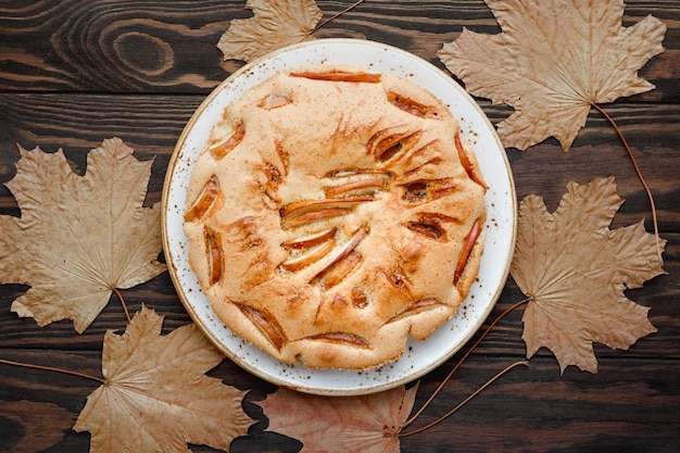 Vista ad alto angolo della torta e delle foglie sul tavolo