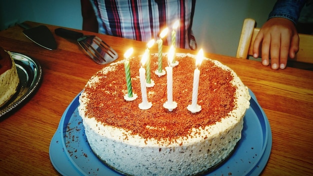 Vista ad alto angolo delle candele accese sulla torta di compleanno