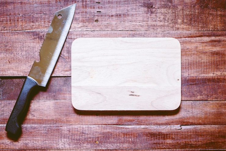 Foto vista ad alto angolo di coltello da cucina e tavola da taglio su tavolo di legno