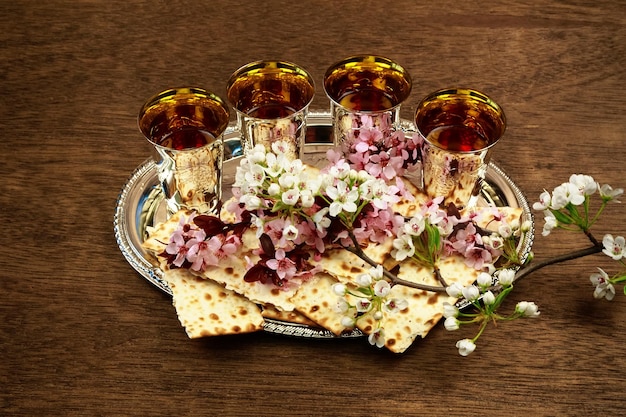 Vista ad alto angolo di cracker con fiori e bevande in vassoio sul tavolo