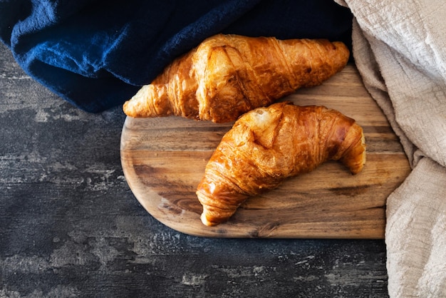 Vista ad alto angolo di croissant su un tavolo da taglio in mezzo al tessuto