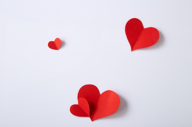 Vista ad alto angolo di forme di cuore rosso su sfondo bianco