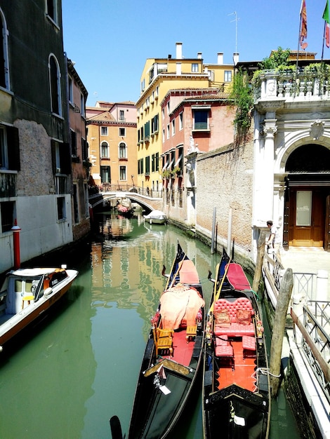 Vista ad alto angolo di gondole ormeggiate nel canale tra gli edifici