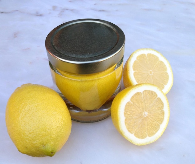 Vista ad alto angolo di limoni in contenitore pieno di acqua su marmo