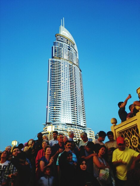 Vista ad alto angolo di persone in piedi contro un grattacielo in città