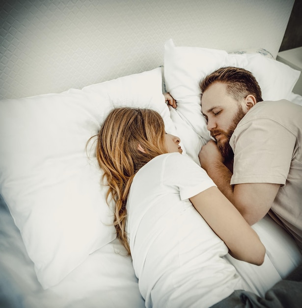Vista ad alto angolo di una coppia che dorme sul letto a casa