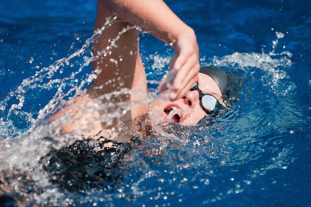 Vista ad alto angolo di una donna adulta che nuota in piscina