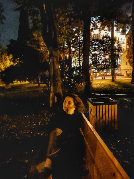Vista ad alto angolo di una donna seduta su una panchina di notte