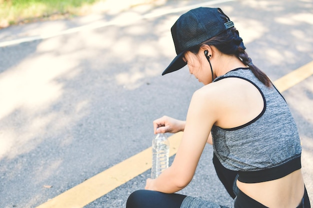 Vista ad alto angolo di una donna sportiva che si riposa sulla strada