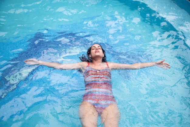 Vista ad alto angolo di una giovane donna in piscina