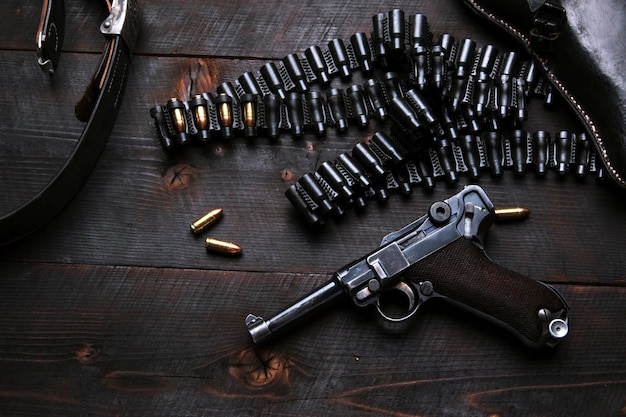 Vista ad alto angolo di una pistola con proiettili su un tavolo di legno